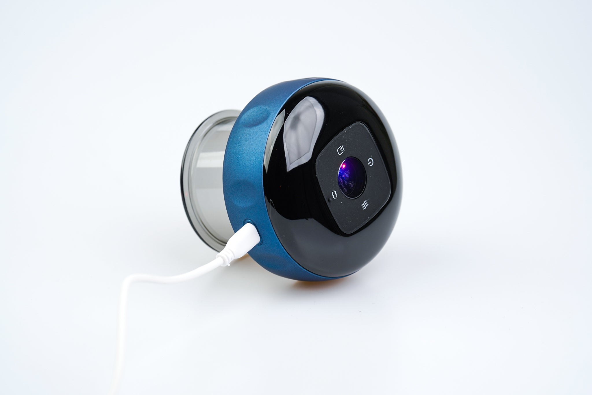 En moderne, sfærisk smart højttaler i blank blå og sort finish, forbundet til en strømkilde via et hvidt kabel. Enheden har en synlig kameralinse og kontrolknapper på en digital grænseflade, der inkorporerer Purely Nordics Smart Cup Basic.